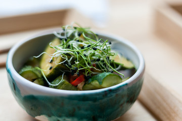 Traditional Asian food. Kimchee  from cucumber pepper and cabbage, decorated with sprouts in a ceramic bowl. Korean food.