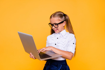 E-studying concept. Side profile close up photo portrait of cute lovely intelligent nice schoolkid watching video skype holding netbook ind hand doing homework isolated background