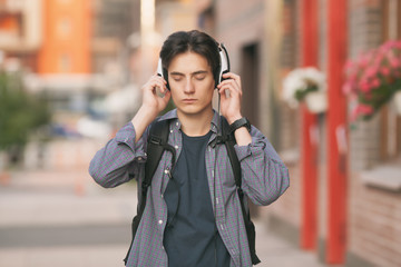 Fototapeta premium A man in headphones listens to music. Fresh air. Street