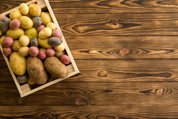 Small wooden crate filled with fresh potatoes
