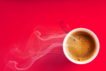 Fragrant coffee on a red background for your advertising. Smoke from hot coffee.