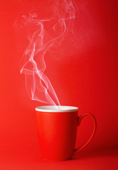 Fragrant coffee on a red background for your advertising. Smoke from hot coffee.