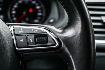 Obraz na płótnie Canvas Modern car interior. Steering wheel with media phone control buttons, navigation multimedia system background. Car interior details. Car detailing