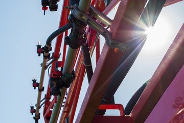 Self-propelled sprayer bar with nozzles for various weather conditions and preparations against the sun