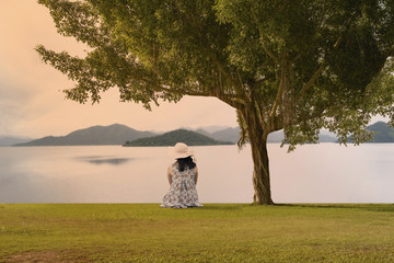 Asian woman sitting on the ground amoung beautiful nature.