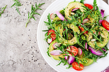 Diet menu. Healthy salad of fresh vegetables - tomatoes, avocado, arugula, radish and seeds on a bowl. Vegan food. Flat lay. Top view
