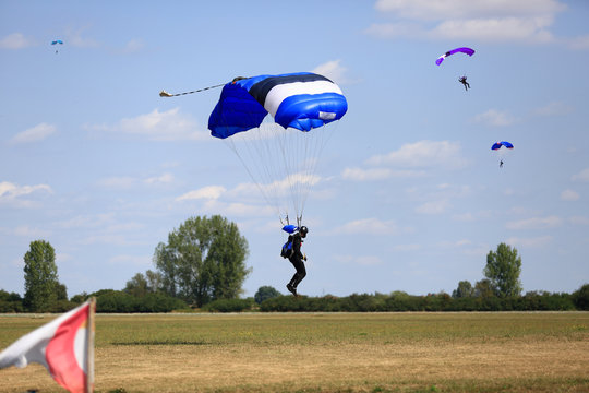 Spadochroniarze lądują na płycie lotniska aeroklubu.