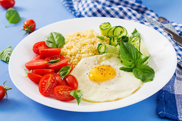 Healthy breakfast. Dietary menu. Millet porridge and tomato, cucumber salad and fried eggs.