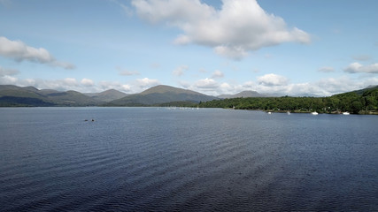 Aerial image of boats on a lake with hills in the distance on a bright summer’s day.