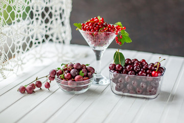 Red currants and berries, on a white table.