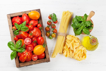 Fresh garden tomatoes and pasta on cooking table