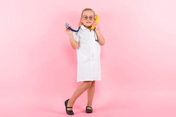 Little girl in doctor costume with banana