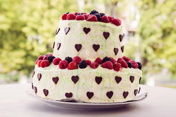 Sweet cake with chocolate hearts and berries