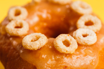 Donut with honey glaze on a yellow background