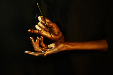 gold hands witn brush isolated on black background