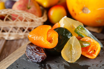 Mix of dried glazed fruits in syrup on wooden background