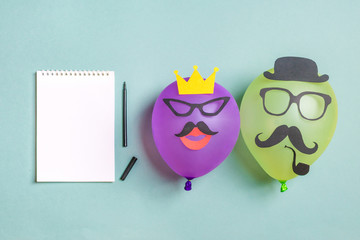 Black paper mustache and glasses on balloon and a notepad with a felt-tip pen Month donations...