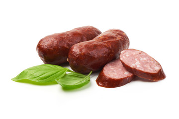 Bratwurst smoked pork sausages with sausage slices and green fresh basil leaves, isolated on white background.