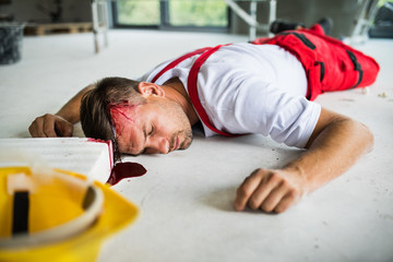 An unconscious man worker lying on the floor after accident on the construction site.