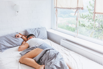 Young man sleeping late in the morning, bedroom