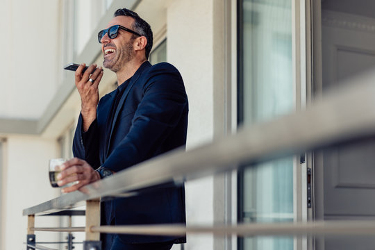 Mature Businessman In Hotel Room Balcony Talking On Phone