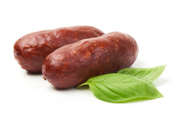 Bratwurst smoked pork sausages with green fresh basil leaves for grill, isolated on white background.