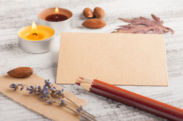 Craft envelope and pencils, lit candles