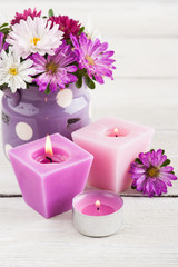 Obraz na płótnie Canvas Purple lit candles and pink garden flowers