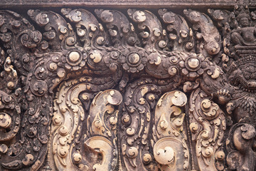 Stone carved bas-relief of Banteay Srei temple in Angkor Wat, Cambodia. Traditional bas-relief closeup photo.