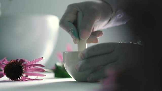 Pharmacist grinds the drug in a white plate