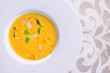 healhty homemade pumpkin soup with herb on white plate, product photography for restaurant and gastronomy