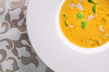 healhty homemade pumpkin soup with herb on white plate, product photography for restaurant and gastronomy
