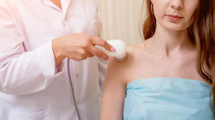 Ultrasound treatment in physical therapy. Doctor using an ultrasound machine to treat the joints and muscles of a patient