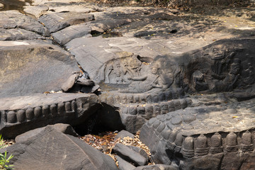 Ancient stone bas-relief, Kbal Spean monument, Cambodia. Traditional khmer stone carving on wild riverside stones