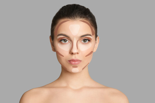 Young woman with beautiful makeup on grey background. Professional cosmetic products