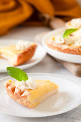 Traditional shortcrust pastry lemon tart with citrus custard and whipped cream