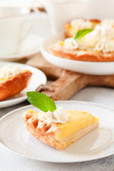 Traditional shortcrust pastry lemon tart with citrus custard and whipped cream