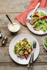 Delicious beet salad on wooden table, top view