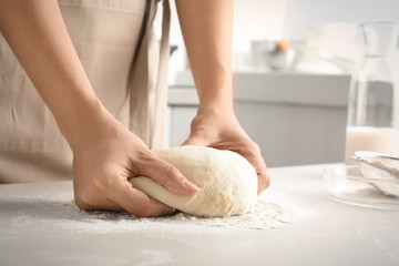 Woman kneading dough for pastry on table