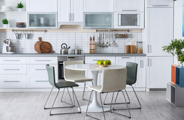 Stylish kitchen interior with dining table and chairs