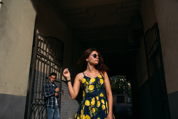 girl on a dark background in sunglasses, from behind a guy near an iron door, lattice.quarrel,