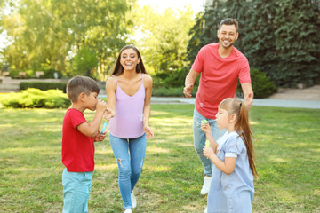 Fototapeta premium Happy family with children spending time together in green park on sunny day
