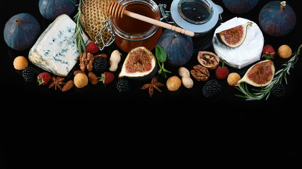 set cheese camembert or brie cheese, cheese with blue mildew with figs, blackberries and raspberries on a shale board isolated on a black background, Flat lay, Copy space