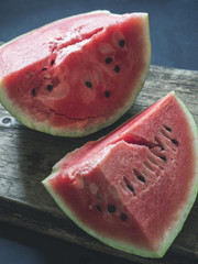 Fresh red ripe sliced watermelon on a wooden background
