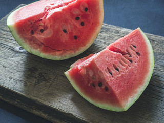 Fresh red ripe sliced watermelon on a wooden background