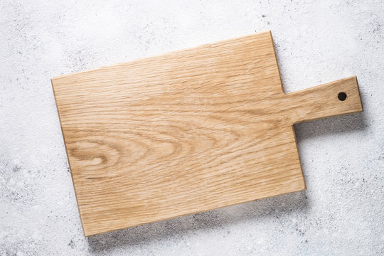 Empty Wooden Cutting Board On White Stone Table.