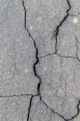 Obraz premium Surface of a gray cracked road 
