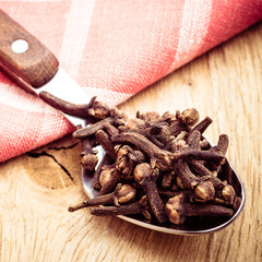 Spice cloves on kitchen spoon