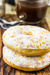 Two donut and a cup of coffee with chocolate on a wood table