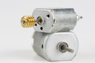 Small electric motor on a white workshop table. Electric drive used in small electrical devices.